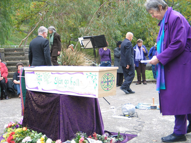 Rev Coralie Ling bends over Caty's beautiful coffin